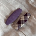 Close-up of premium purple fabric hair clips in solid and plaid textured patterns - Purple Series Pair - Large Oval