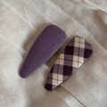 Detail view of two fabric BB hair clips in solid purple and plaid patterns on beige linen - Purple Series Pair - Large Teardrop