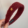Detalle de diadema de felpa rojo vino con dije de oso dorado y etiqueta artesanal - Rojo