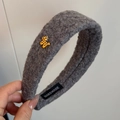 Detail of grey fuzzy headband featuring a gold bear charm and handmade label tag - Gray