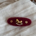 Dettaglio molletta in feltro bordeaux con cavallo a dondolo dorato e piccoli strass - Fermaglio Cavallo a Dondolo Ovale