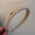 Detail view of a thick plaid fabric headband with yellow brand label and soft texture - Beige Plaid Headband