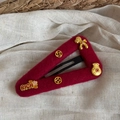 Detailed view of dark red felt hair clip featuring gold Rich lettering and lucky coin symbols - New Year Hair Clip - Hollow Triangle (FJ891931)