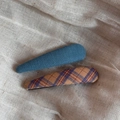 Détails d'un ensemble de barrettes en tissu à carreaux sur fond beige texturé - Paire Série Bleue - Goutte d'eau Mince