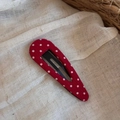 Détail d'une pince à cheveux triangulaire rouge à pois blancs sur un fond en lin rustique - Style Goutte d'eau Évidé / Rouge à Pois