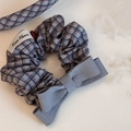 Dettaglio dell'elastico per capelli scozzese grigio con etichetta Rise Above e fiocco - Elastico con Fiocco a Quadri Grigio Blu