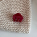 Close-up of a glossy deep red acetate hair claw clip on a beige knit fabric background - Cloud Small Claw-Red