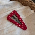 Gros plan sur pince à cheveux triangle rouge à pois blancs sur fond en tissu tressé - Style Grand Triangle Creux / Rouge à Pois