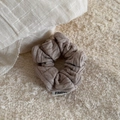 Detailed close-up of knitted ribbed texture in taupe with a woven brand label - Cable Knit Scrunchie-Coffee