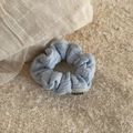 Detail of light blue textured fabric scrunchie with woven label on a soft textile background - Cable Knit Scrunchie-Blue