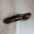 Detailansicht der Haarspange aus Harz mit Schildpattmuster auf beigem Strickstoff - Entenschnabel-Clip (Hohl) / Schildpatt Hohl-Stil
