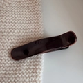 Makro-Detail von glänzender dunkelbrauner Haarspange aus Harz mit goldener Prägung - Entenschnabel-Clip (Massiv) / Rotbraun