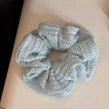 Détail d'un chouchou en dentelle bleu clair avec motifs évidés et texture plissée - Rayures Ajourées - Bleu