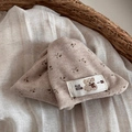 Dettaglio ravvicinato di un cappello in maglia per neonati a fiori con toppa a forma di orso - Pinza Triangolare Cachi Con Toppa Orsetto E Motivo Floreale