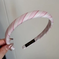 Nahaufnahme des rosa-weiß gestreiften Stoff-Haarbandes mit Textur und Marken-Label - Süßes Rosa Gestreiftes Haarband Schmal