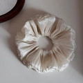 Detalle de un elegante coletero plisado blanco crema con suave textura satinada - Blanco