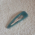 Macro detail of teal acetate teardrop hair clip with France Handmade gold lettering - Cyan