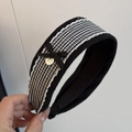 Close-up of black fabric headband with checkered ribbon, lace trim and golden bow charm - Checkered Black White Headband