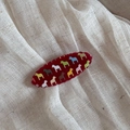 Detail of red oval hair comb featuring colorful Dala horse patterns on wavy resin edge - Red Hair Clip