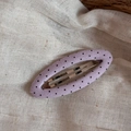 Detailed close-up of a lavender fabric BB clip with black polka dots on a linen background - Purple Fine Polka Dot Hollow Oval Style