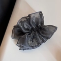 Detailed view of dark grey organza scrunchie with silver glitter and pleated texture - Gray