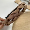 Dettaglio del cerchietto intrecciato beige con perle e texture spessa a maglia antiscivolo - Caffè