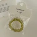 Vista macro di elastici a spirale trasparenti e verde oliva su carta bianca - Verde