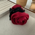 Vista dettagliata di un grande fermaglio per capelli a rosa in raso rosso su un vassoio - Rosso