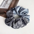 Detail view of French velvet and satin scrunchie with dual texture and brand label - Gray