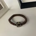 Detalle de un coletero marrón plisado con un adorno cuadrado de leopardo - Café Cuadrado de Leopardo