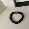 Detail of black satin scrunchie featuring a stylish leopard print heart-shaped resin charm - Black-Heart Leopard