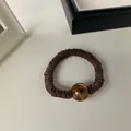 Detail of dark brown pleated scrunchie with a tortoiseshell patterned resin bead - Coffee-Round Bead