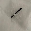 Elegante fermaglio per capelli con fiori di perle e design minimalista su sfondo bianco ruvido - Fiore Bianco