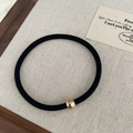 Detail of a black high-elastic hair tie with a polished rose gold metal bead accent - Black