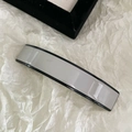 Vue détaillée d'une pince à cheveux rectangulaire en acétate gris et noir sur fond blanc - Gris clair