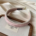 Detailed shot of handmade pink satin headband with white faux pearls on a tray - Pink