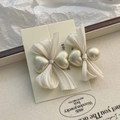 Détail de la barrette à nœud en tissu crème avec perles en cœur sur plateau élégant - Perle Cœur - Blanc Nacré