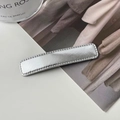 Nahaufnahme einer rechteckigen silbernen Lederhaarspange mit Perlrand-Metallrahmen - Dünner Langer Stil