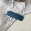 Detailed view of the dark blue denim fabric texture and stitching on the rectangular hair clip - Aqua