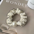 Dettaglio di scrunchie crema a pois con bordi in pizzo e perla bianca decorativa - Pois Bianchi