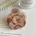 Vista dettagliata di un fermaglio per capelli floreale in acetato con molla dorata - Caffè Rosa