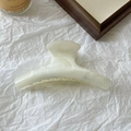 Dettaglio della molletta per capelli effetto marmo crema su sfondo bianco con texture - Gradiente Crema