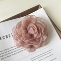 Gros plan d'une pince à cheveux camélia en tulle 3D de couleur rose poudré élégante - Vieux rose