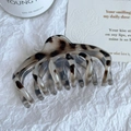 Détail d'une pince à cheveux motif léopard en acétate sur un papier blanc élégant - Style Carène (8cm)
