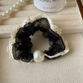 Dettaglio dell'elastico per capelli in rete nera con pizzo bianco e grande perla elegante - Nero - Stile Perla