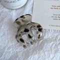 Détail d'une grande pince à cheveux motif léopard sur un fond texturé blanc - Style Griffe Citrouille (5cm)