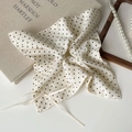 Detailaufnahme von cremefarbenem Polka-Dot-Haargummi mit Seidentextur und Schleifenband - Punkte Kopftuch