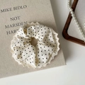 Detailaufnahme des cremefarbenen Polka-Dot-Spitzen-Haargummis mit Häkelkante auf Leinen - Haargummi mit Spitzenkante