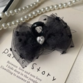 Dettaglio della molletta per capelli con fiocco in pizzo nero e strass a cuore - Fiocco nero a pois