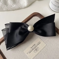 Detalle de elegante pinza para el pelo con lazo de satén negro y malla con perla - Negro